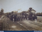 Historická fotografie úzkorozchodných vlaků v Kocmyrzówě; v pozadí výpravní budova.