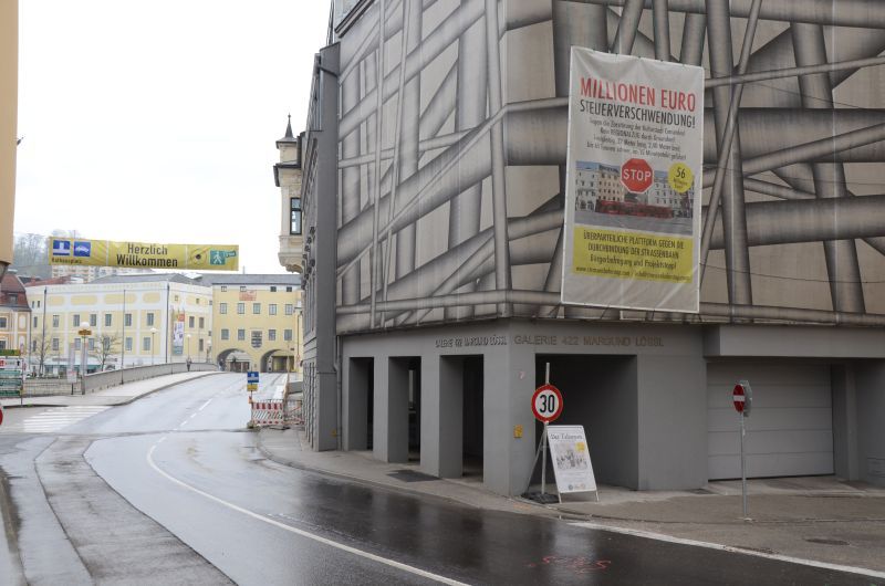 Pohled od Klosterplatz na most pes Traun s plaktem protestujcm proti stavb propojen obou drah