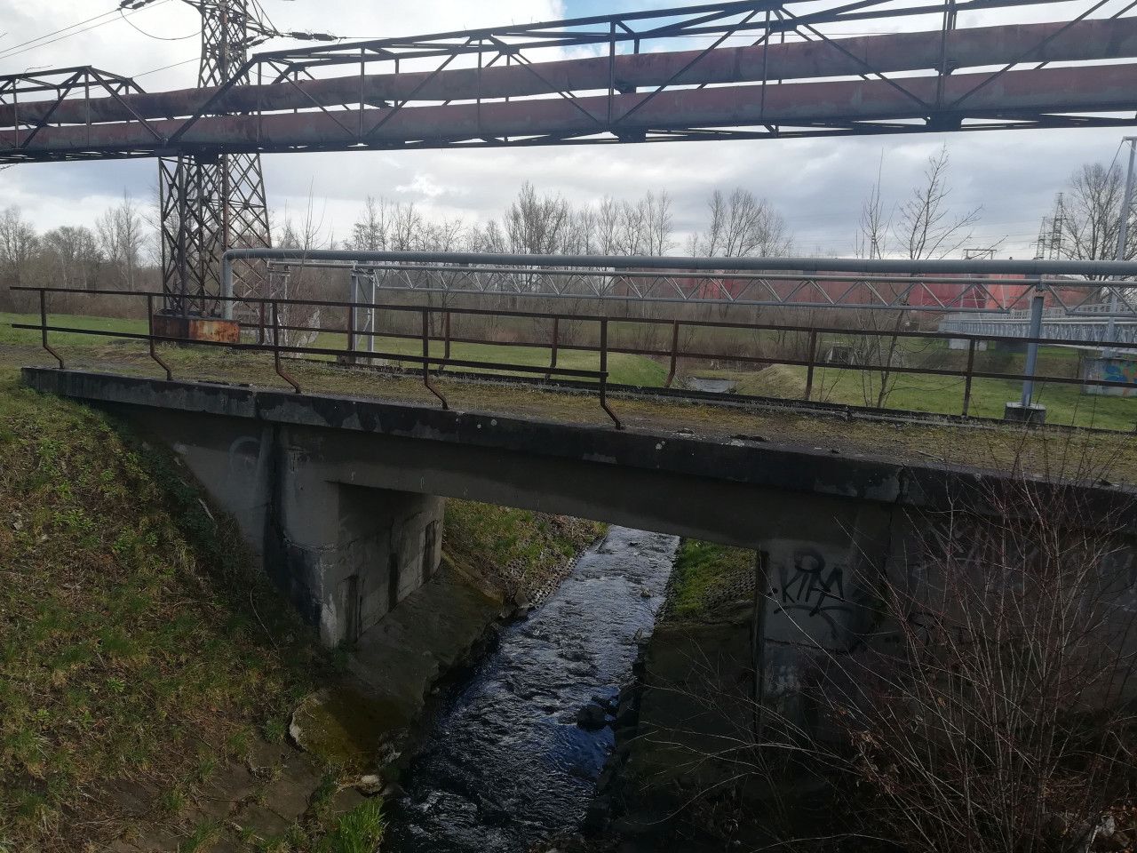 Mostek pes kanl. Most vpravo je cyklostezka a budova vzadu je Arel OZO (zpracovn odpadu).