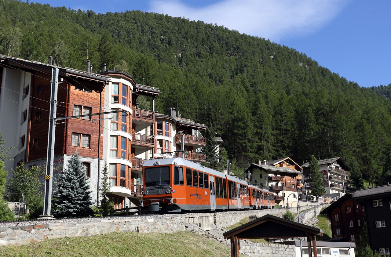 Odpoledn vlak z Gornergratu projd zstavbou Zermattu.