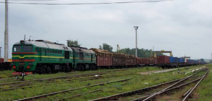 Širokorozchodný nákladní vlak v Dorneşti se strojem 2M62 UZ, který z Ukrajiny přivezl po splítce normálního a širokého rozchodu dřevo do závodu Holzindustrie Schweighofer.